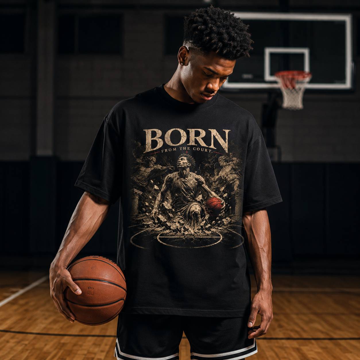 Person wearing a black t-shirt with 'Born from the Court' graphic and holding a basketball on a basketball court.