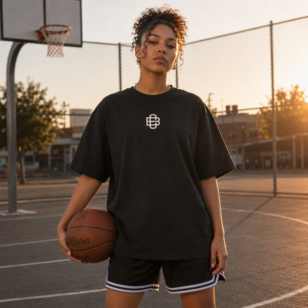 Person holding a basketball on a court with a sunset background