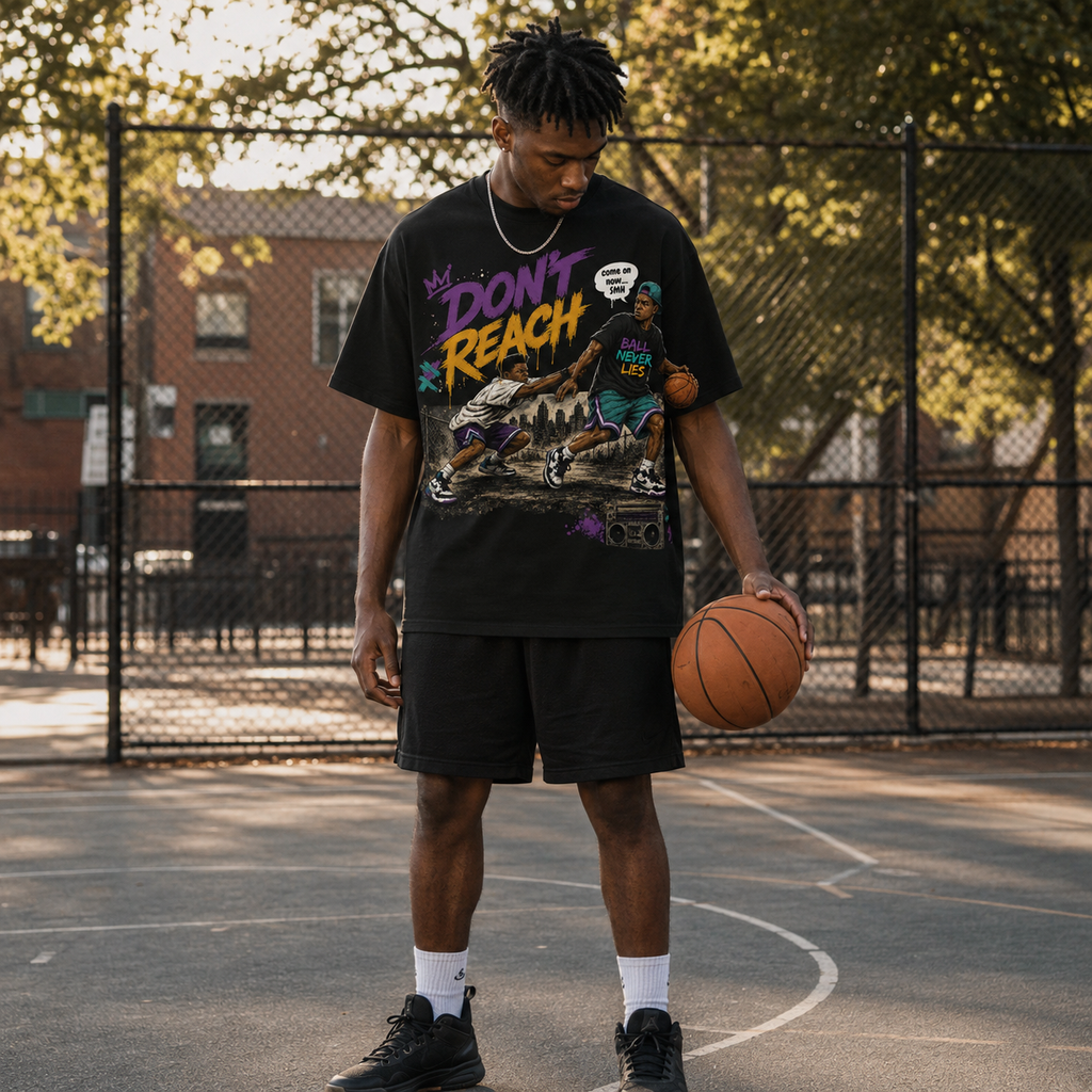 Person holding a basketball on a court wearing a graphic t-shirt