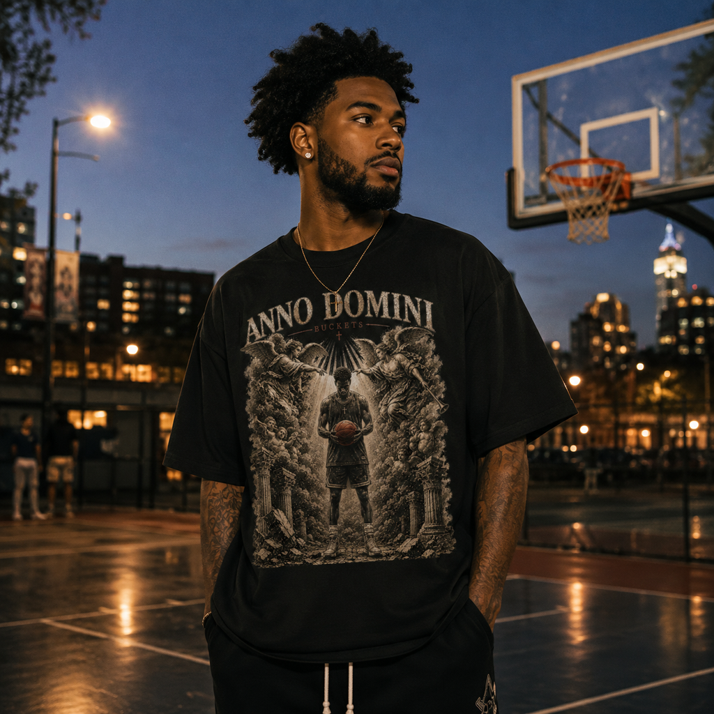 Man wearing a black Bucket Getter t-shirt on a basketball court at night