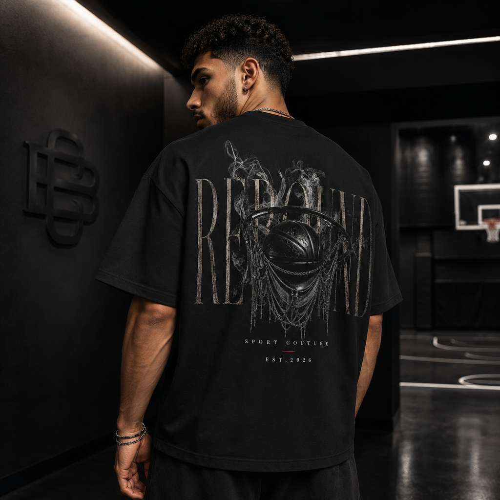 Man wearing a black t-shirt with a graphic design on the back in an indoor setting.