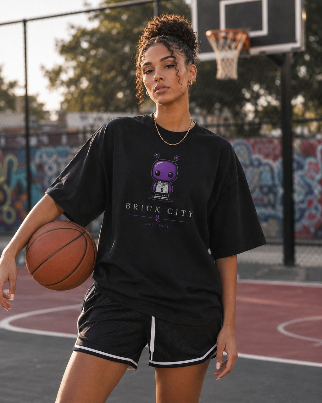 Person holding a basketball on a basketball court with graffiti in the background