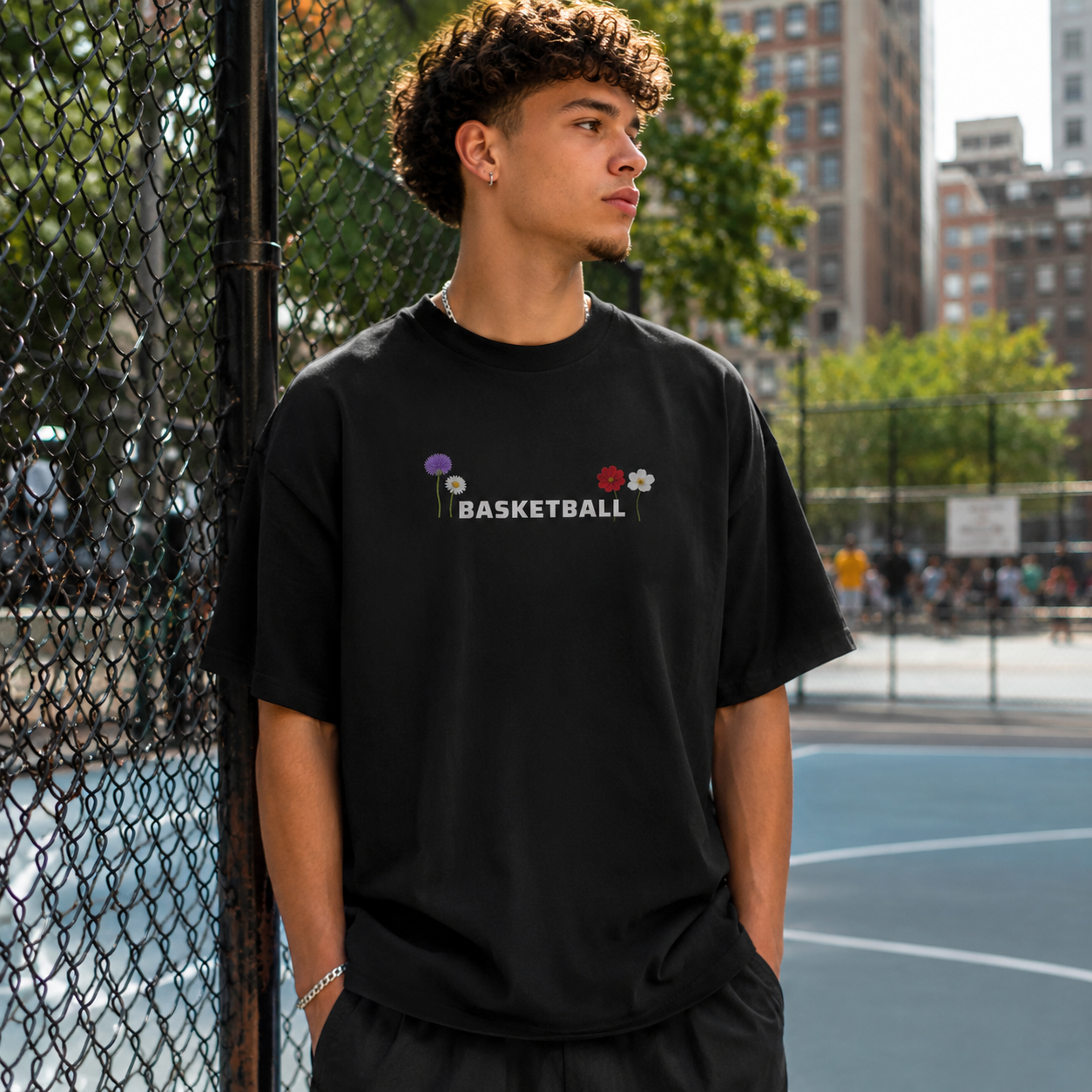 Person wearing a black t-shirt with 'BASKETBALL' and graphics on a basketball court.