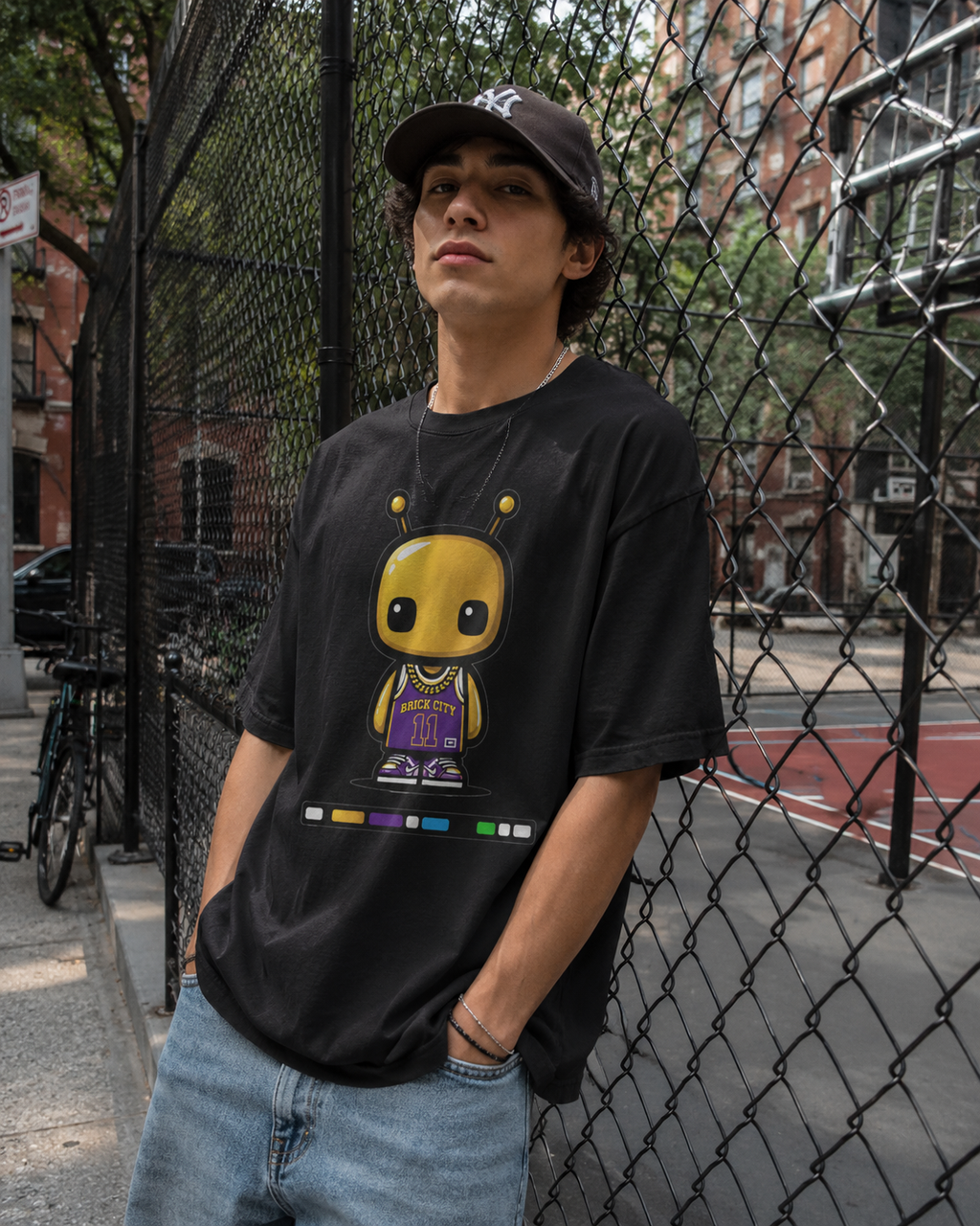 Person wearing a black t-shirt with a graphic design, standing in an urban setting.