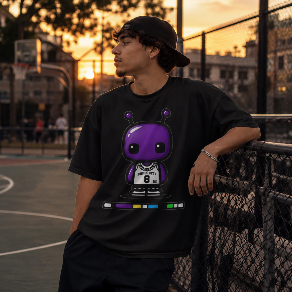 Person wearing a black t-shirt with a purple graphic design on a basketball court at sunset.