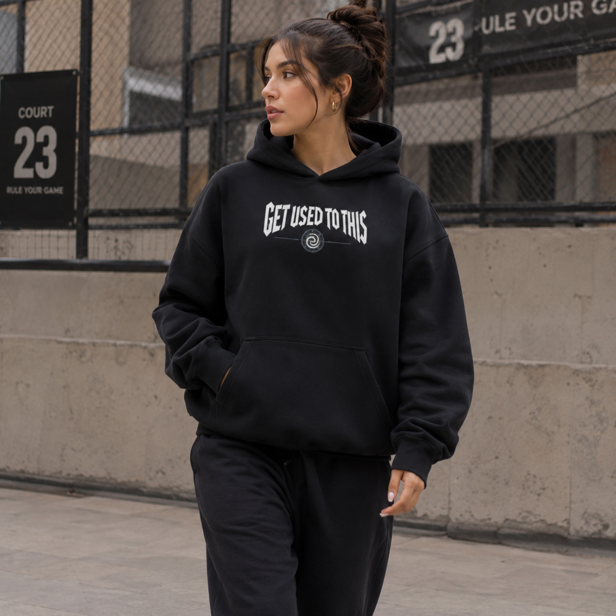 Woman wearing Get Used To This black basketball streetwear hoodie courtside
