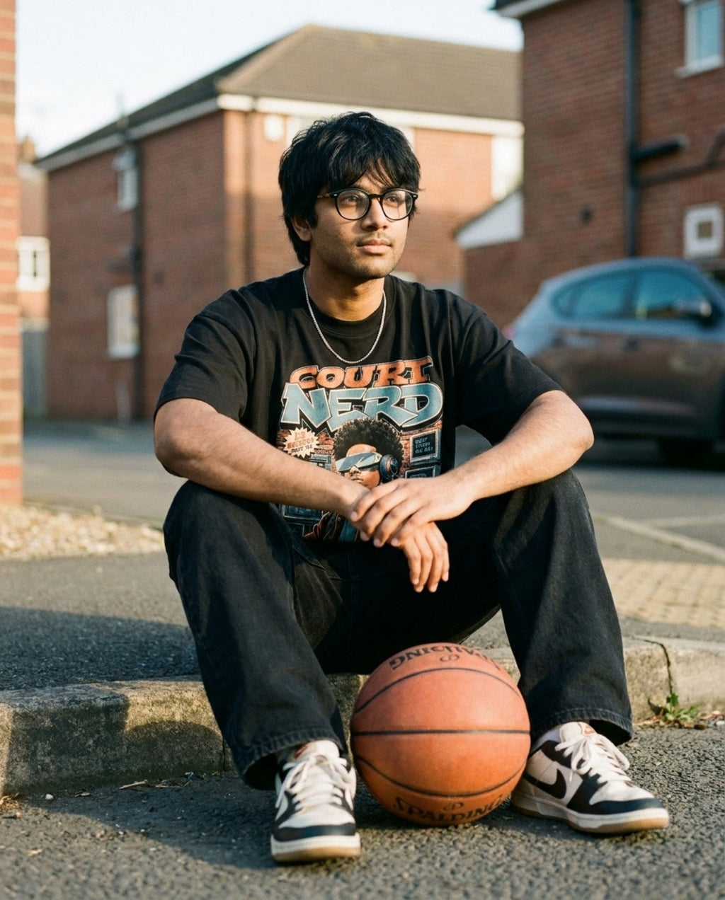 Hoop Nerd Tee seated lifestyle photo with basketball