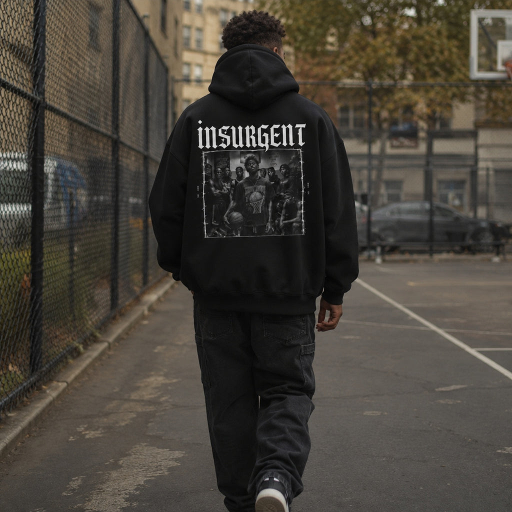Man wearing Insurgent hoodie back graphic on an outdoor basketball court