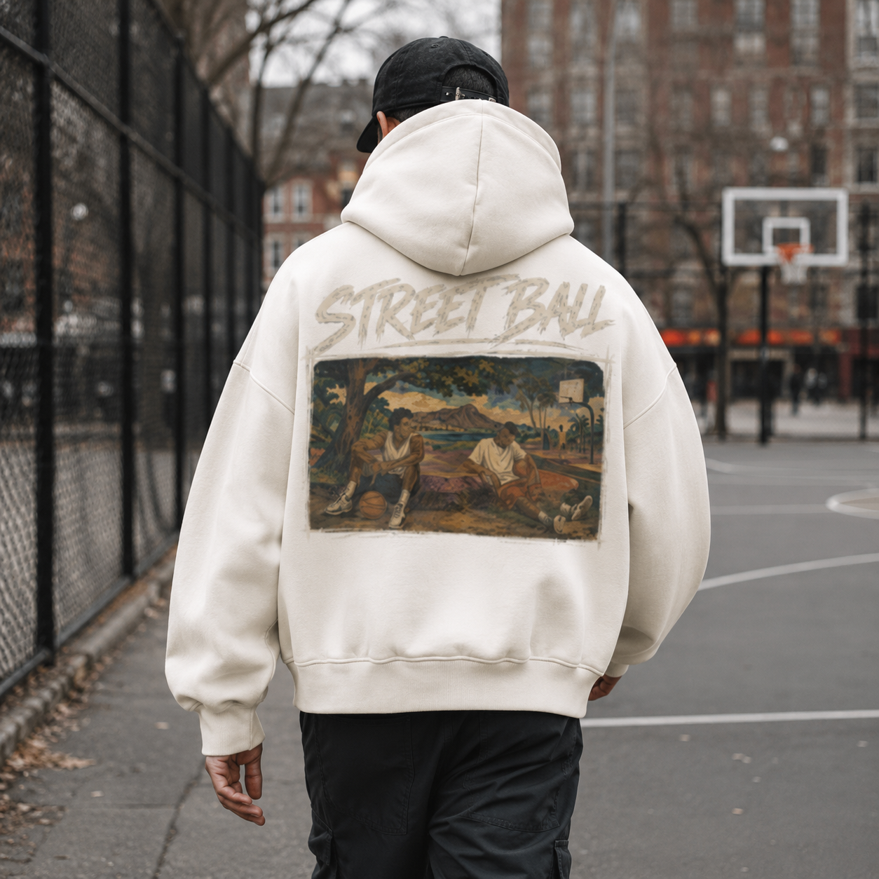 Man wearing light beige Streetball hoodie back art print on an outdoor court