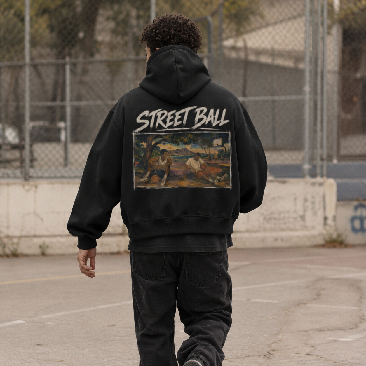 Man wearing black Streetball hoodie back art print on an outdoor court