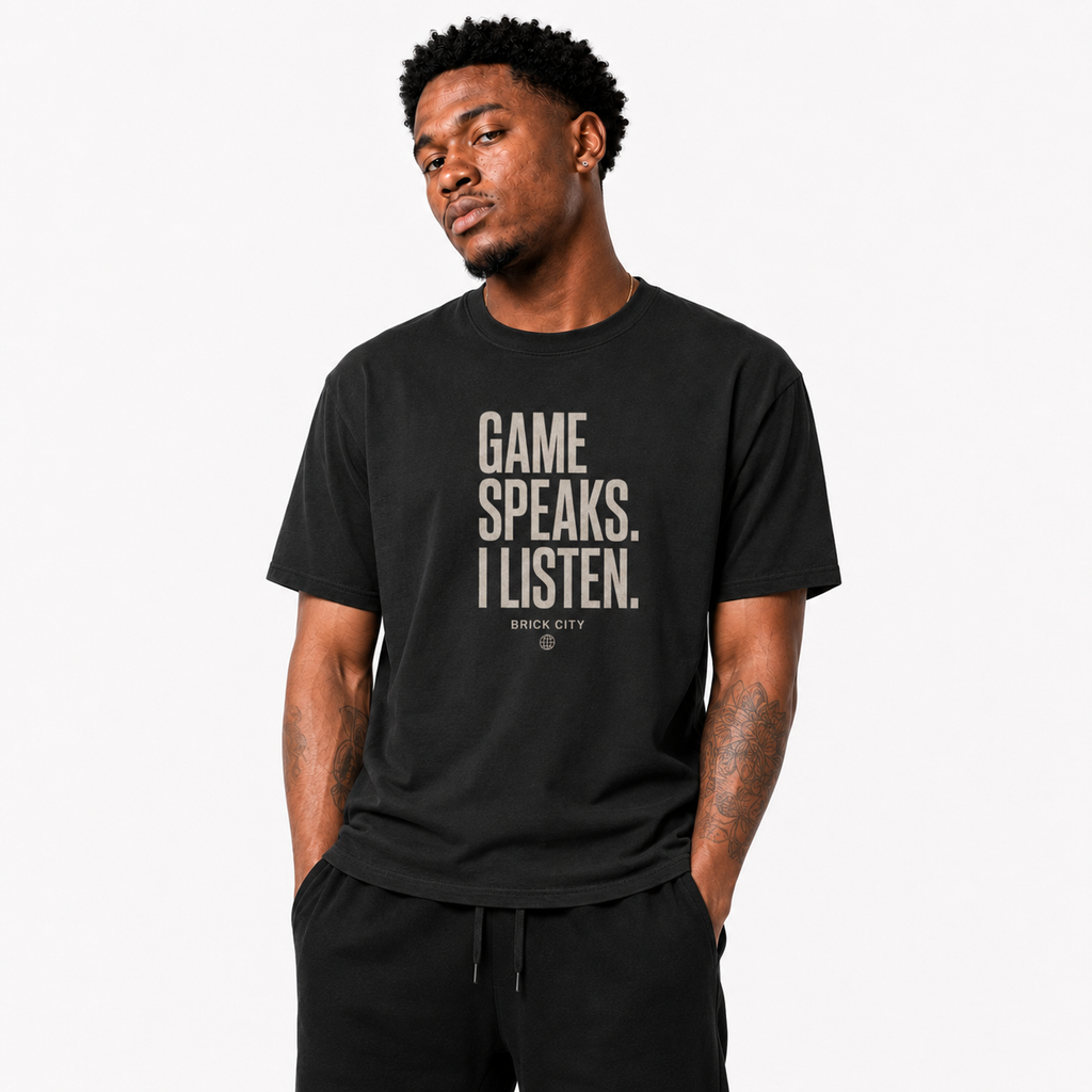 The Game Speaks, I Listen T-Shirt on Brick City model in studio view one